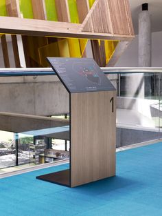 a wooden podium sitting on top of a blue carpeted floor next to a building