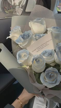 a bouquet of white roses sitting in the back seat of a car