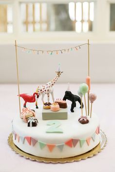 a birthday cake decorated with animals and desserts