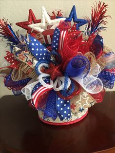 a red, white and blue centerpiece with stars on the top is sitting on a table