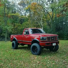 a red pick up truck parked in the grass