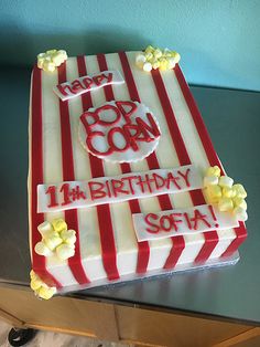 a red and white striped birthday cake with popcorn