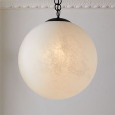 a light fixture hanging from a ceiling in a room with white walls and carpeting