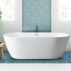 a white bath tub sitting on top of a blue rug