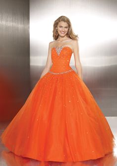 a woman in an orange ball gown posing for the camera