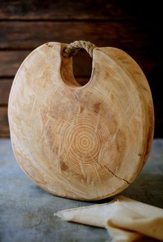 a wooden bowl sitting on top of a table next to a piece of paper and a knife