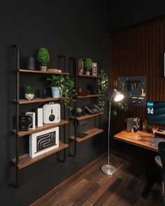 a desk with a computer and some plants on the shelves next to it, along with other office supplies