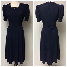 A 1940's Navy Gabardine Swing Dress, with a square neckline, buttonhole detail. Center front has horizontal pin tucks, wrapping around  the waist and below the waist. Side front has vertical pin tucks, shirred below the bust. The upper back dress is fitted with waistline darts, top stitched waistline,  a center back metal zipper and self made back ties.  There are pleats at the top of the sleeves and stitched tucks at the bottom of sleeves. The sleeves have padding. There are 5 gores in the front skirt, and 4 gores in the back. A great Swing dress! Measurements:      Shoulder to shoulder: 13 1/2"      Bust: 38"      Waist: 28"      Bottom of pin tucks: 31"      Hips (7" below waist): 37"      Front shoulder to hem: 42 1/2"      Shoulder to bottom of tucks: 19"      Sleeve length from shoul Solid Color Fitted Knee-length Vintage Dress, Elegant Fitted Vintage Dress In Solid Color, Elegant Solid Color Fitted Vintage Dress, Fitted Vintage Dress In Solid Color, Classic Fitted Dresses For Vintage Fashion, Fitted Vintage 1950s Dress For Workwear, Fitted 1950s Vintage Dress For Work, 1950s Fitted Vintage Dress For Work, 1950s Style Fitted Dress With Buttons