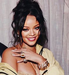 a close up of a person with a ring on her finger and wearing a yellow dress