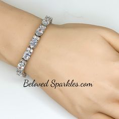 Lily Oval Cubic Zirconia 28ct Silver Tennis Bracelet. This statement tennis style is created with oval and round cubic zirconia. This luxe piece paired with glistening accompaniments is perfected compliment for the event attire. Only the best quality cubic zirconia is use on our fine jewelry collection. Our genuine rhodium finish is achieved using an electroplating process that coats the item with heavy layers of rhodium, a close cousin to platinum, which gives our jewelry a platinum luster. Thi White Crystal Tennis Bracelet For Party, White Sparkling Stones Tennis Bracelet For Wedding, Oval Cubic Zirconia Tennis Bracelet For Wedding, Wedding Oval Cubic Zirconia Tennis Bracelet, Wedding Crystal Tennis Bracelet Sparkling, Sparkling Crystal Tennis Bracelet For Weddings, Crystal Sparkling Tennis Bracelet For Wedding, White Round Tennis Bracelet For Party, Wedding Sparkling Crystal Tennis Bracelet