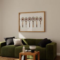 a living room with a green couch and four racquets mounted on the wall