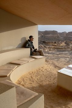 a man sitting on a bench in the desert