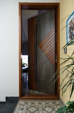 an open door leading into a room with a tiled floor and potted plant in the corner