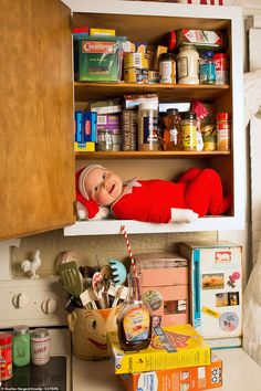 an elf is hiding in the kitchen cupboard