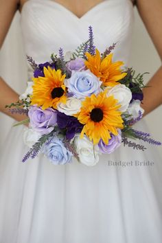 a bride holding a bouquet of sunflowers and blue roses on her wedding day