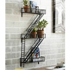 a set of three metal shelves with plants on each shelf and bookshelf below