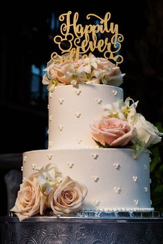 there is a wedding cake with flowers on the top and happy anniversary written on it