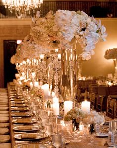 a long table with white flowers and candles