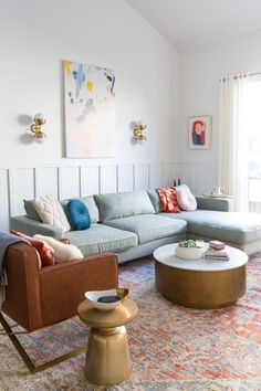 a living room filled with lots of furniture and pillows on top of a colorful rug