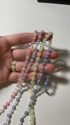 a hand is holding some tiny beads