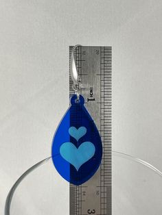 These acrylic heart inlay earrings feature stainless steel ear wires with teardrop accent. Lightweight and comfortable with silicone earring backs. These two tone blue heart inlay earrings are a perfect gift for Mothers' Day, Birthdays or any special occasion. Please keep in mind that each piece will vary slightly due to the variations of the acrylic material and the handmade nature of the product. The drop length is approximately 2.5” from top of ear wire to bottom of earring. Blue Heart-shaped Earrings For Valentine's Day, Blue Heart Charm Earrings For Valentine's Day, Valentine's Day Teardrop Earrings, Valentine's Day Gift Blue Earrings, Blue Heart-shaped Earrings With Ear Wire, Blue Heart Earrings For Valentine's Day, Blue Earrings For Valentine's Day Gift, Blue Heart-shaped Earrings With Heart Charm, Gift Blue Heart Shaped Earrings