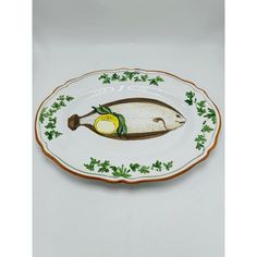 a white and green plate with a fish on it