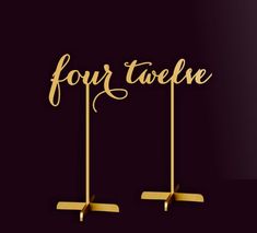 two gold cake toppers with the word four twelve written on them in cursive font