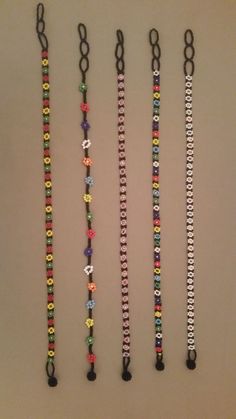 four different colored bracelets hanging on a wall