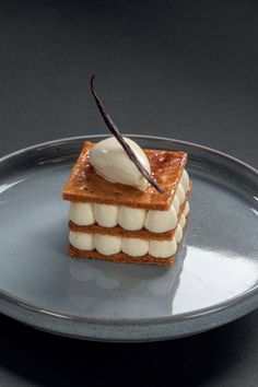 a piece of cake on a silver plate with a chocolate stick sticking out of it