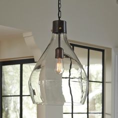 a kitchen with an island and large glass pendant light fixture hanging from the ceiling above it