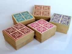 four wooden boxes with designs on them sitting next to each other in front of a white background