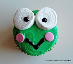 a green cupcake with googly eyes on it