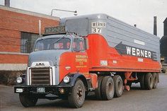 an orange and black truck is parked in front of a brick building with the words meiner on it