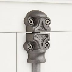 a close up of a door handle on a white cabinet with knobs and holes