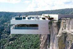 a house on top of a cliff in the middle of trees and mountains, with an outdoor dining area overlooking it