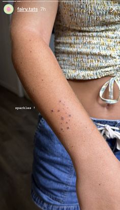 a woman's arm with small black dots on her left side and the word, fairytats