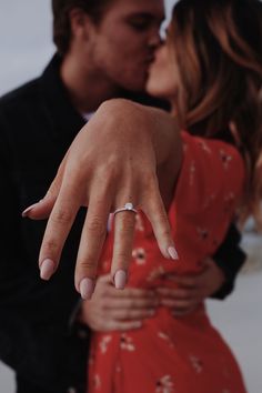 a man and woman kissing with their fingers touching each other