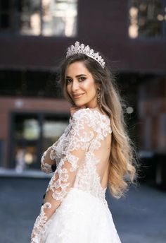 a woman in a wedding dress with a tiara on her head is posing for the camera