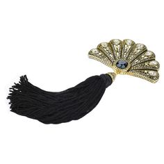 a black and gold fan shaped brooch with crystal stones on it's side