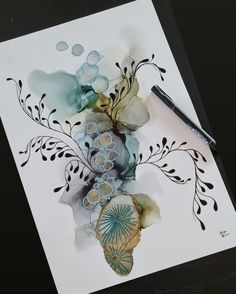 an artistically designed piece of paper with watercolors and ink on white paper