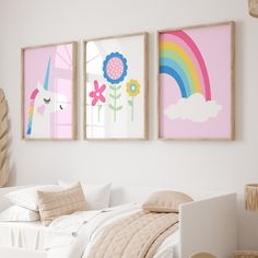 three framed pictures hang on the wall above a bed in a child's bedroom