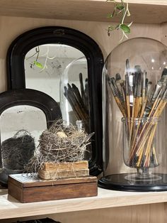 the shelves are filled with different types of pens and pencils in glass jars on top of wooden boxes