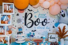 a table with balloons, cake and decorations on it for a little boo birthday party