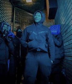 a group of people standing next to each other in front of a brick wall and door