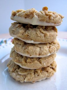 a stack of cookies sitting on top of a white plate covered in frosting and toppings