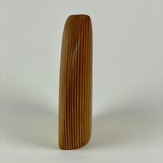 a tall wooden vase sitting on top of a white table