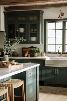 a kitchen filled with lots of green cabinets and counter top space next to a window