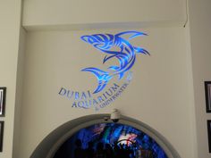 the logo for dubai aquarium and underwater park is projected on the wall behind an arched doorway