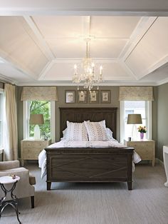 a bedroom with a large bed and chandelier hanging from it's ceiling