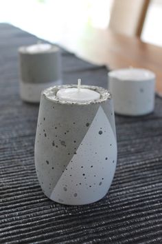 three candles sitting on top of a table next to each other